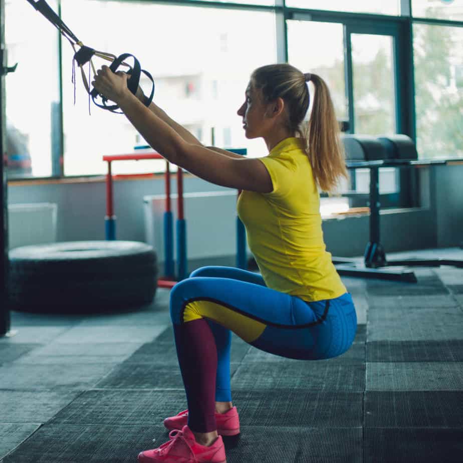 Girl performing TRX Squat