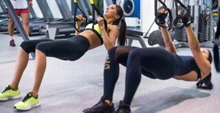 TRX group training with two women performing table top pullup