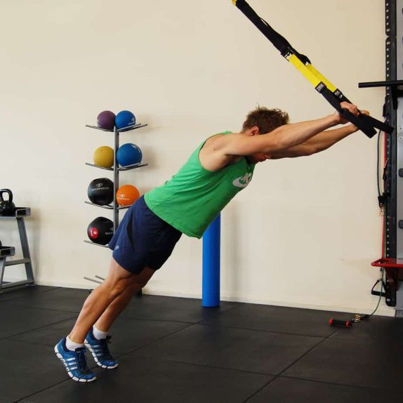 Man performing the TRX standing roll out